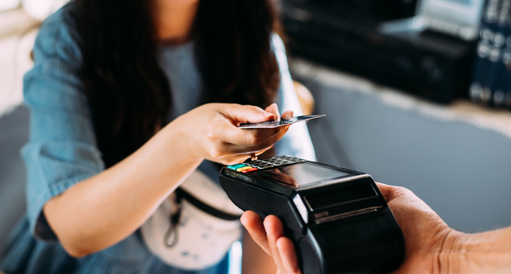 Mujer pagando en un datáfono con su tarjeta de crédito o débito