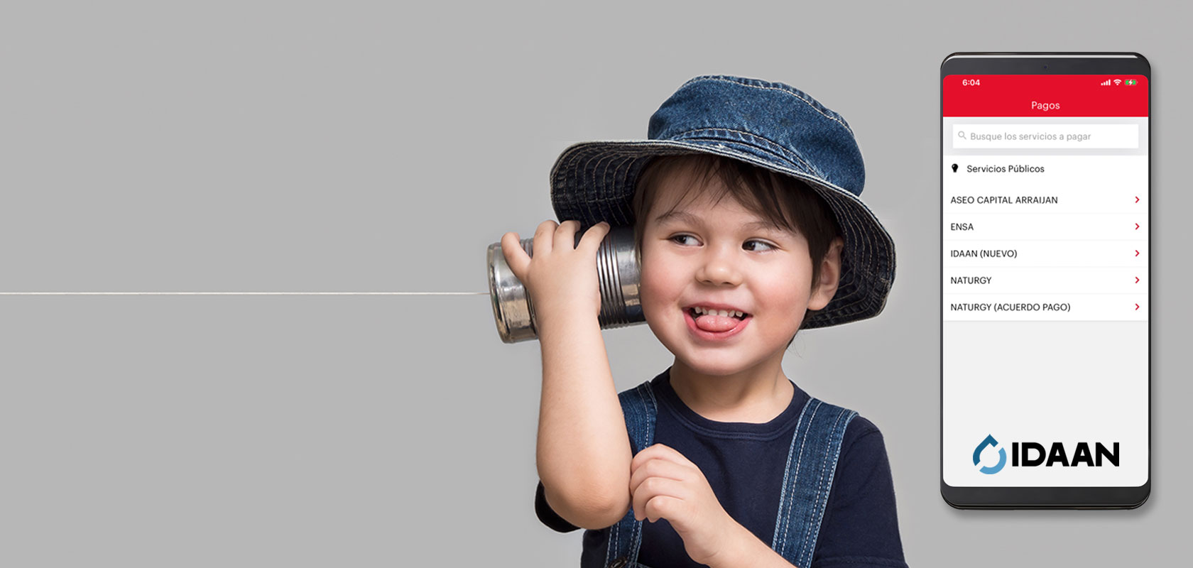 Niño jugando a hablar por teléfono con latas e hilos