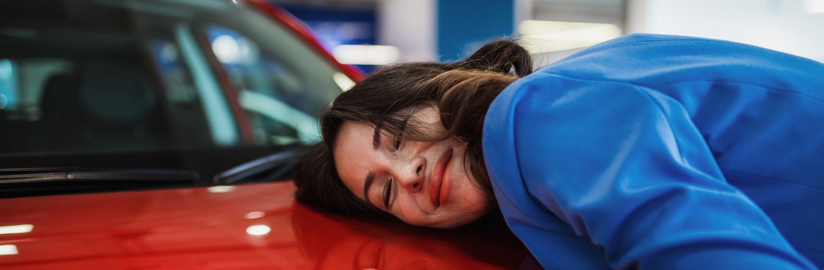 Imagen de chica feliz junto a su nuevo auto color rojo
