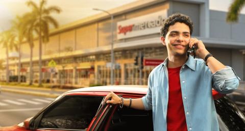 Persona sonriente hablando por telefono y buscando donde aplicar los beneficios de La Roja BAC