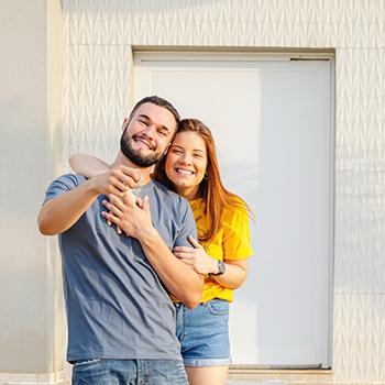Pareja feliz mostrando las llaves de su nuevo hogar