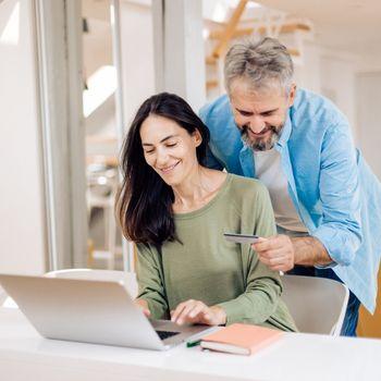 Pareja feliz verificando su certificado a plazo creado con BAC Honduras
