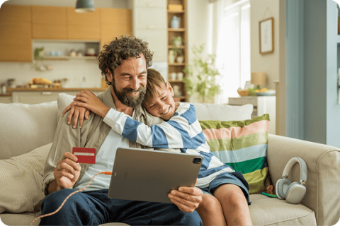 Niño abrazando a su papa mientras verifican su cuenta infantil y juvenil de BAC Costa Rica