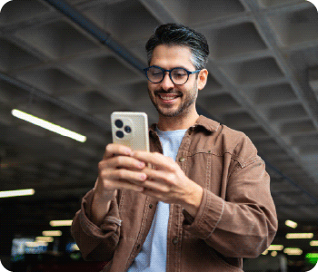Persona sonriente en su telefono trasladando el monto de su tarjeta a cuotas