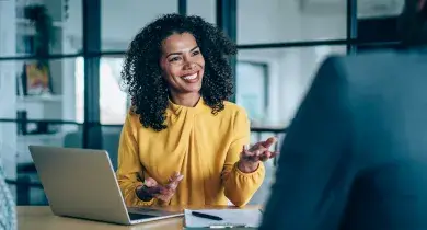 Mujer sonriendo mientras explica a alguien