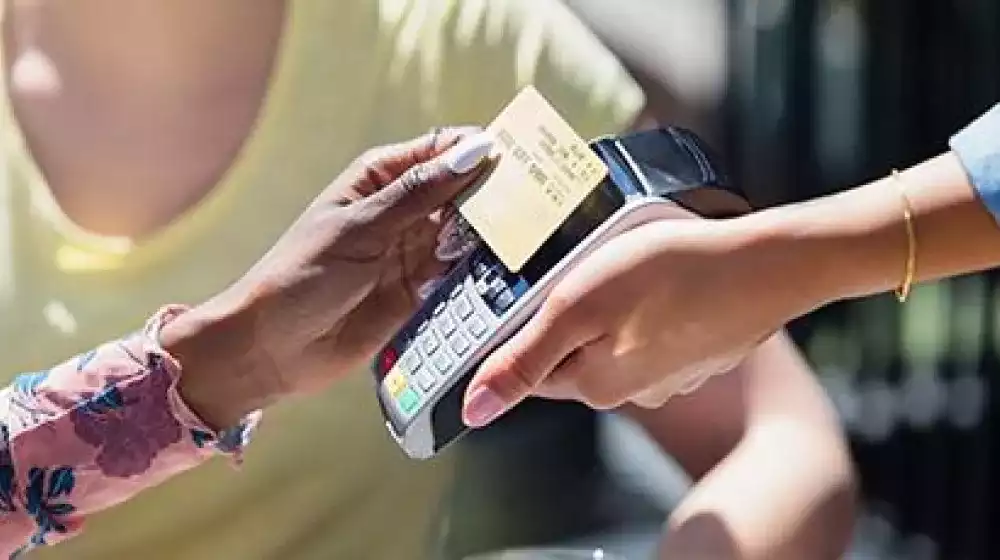 Persona realizando un pago con su tarjeta gold