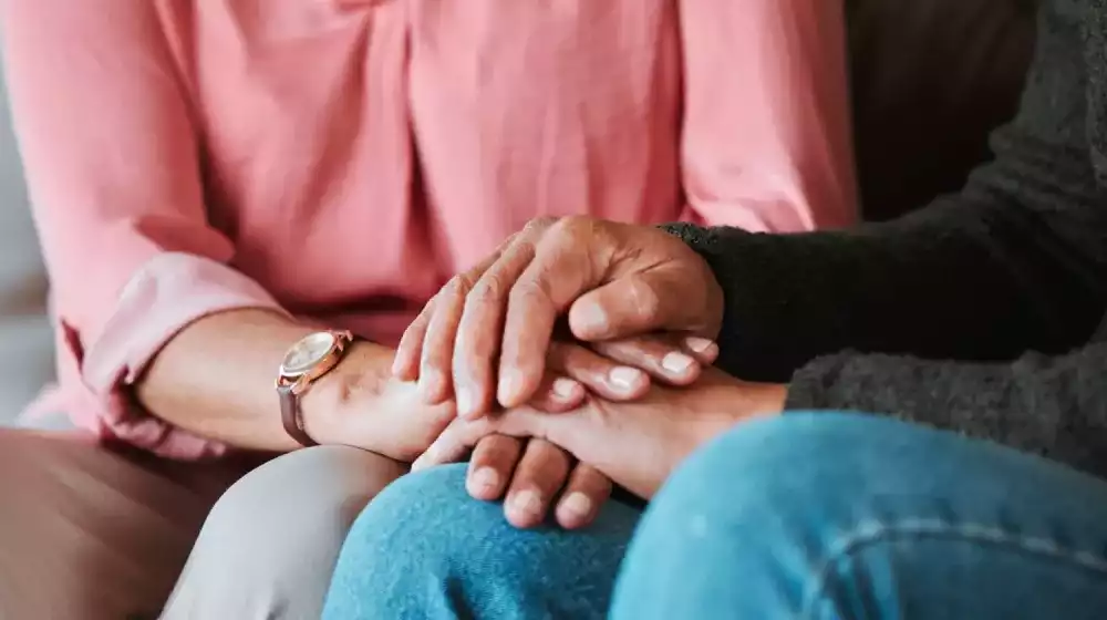 personas sosteniendo manos en señal de apoyo por duelo
