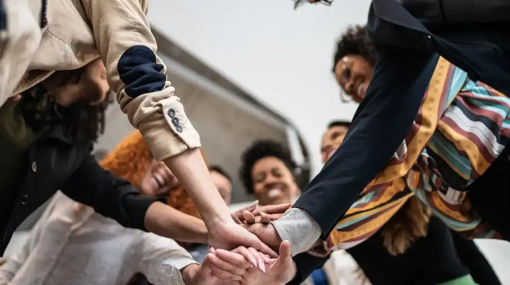 personas con las manos juntas
