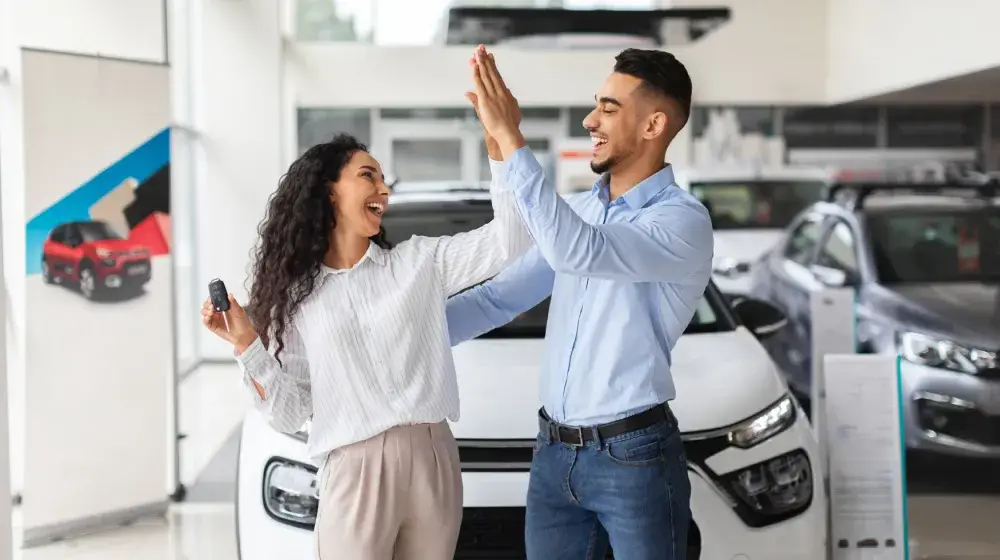 Pareja feliz con vehículo nuevo 