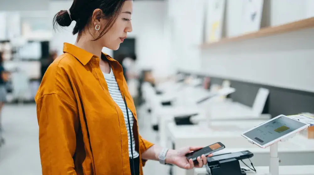 Persona pagando una compra a minicuotas con su tarjeta Lifemiles empresarial de BAC