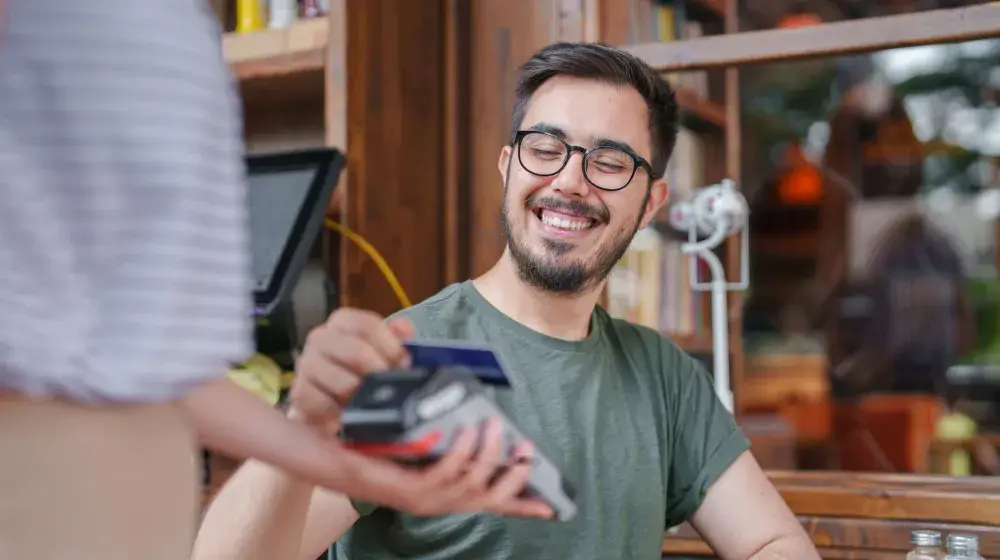 Persona pagando con su tarjeta Lifemiles Empresarial de BAC a tasa cero