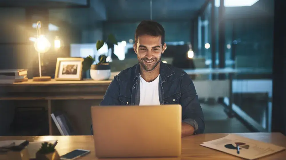 Joven feliz viendo su computadora