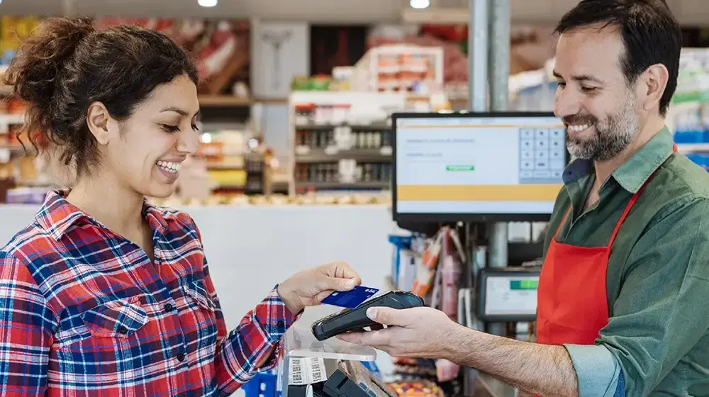 Persona pagando en el supermercado con su tarjeta BAC Guatemala
