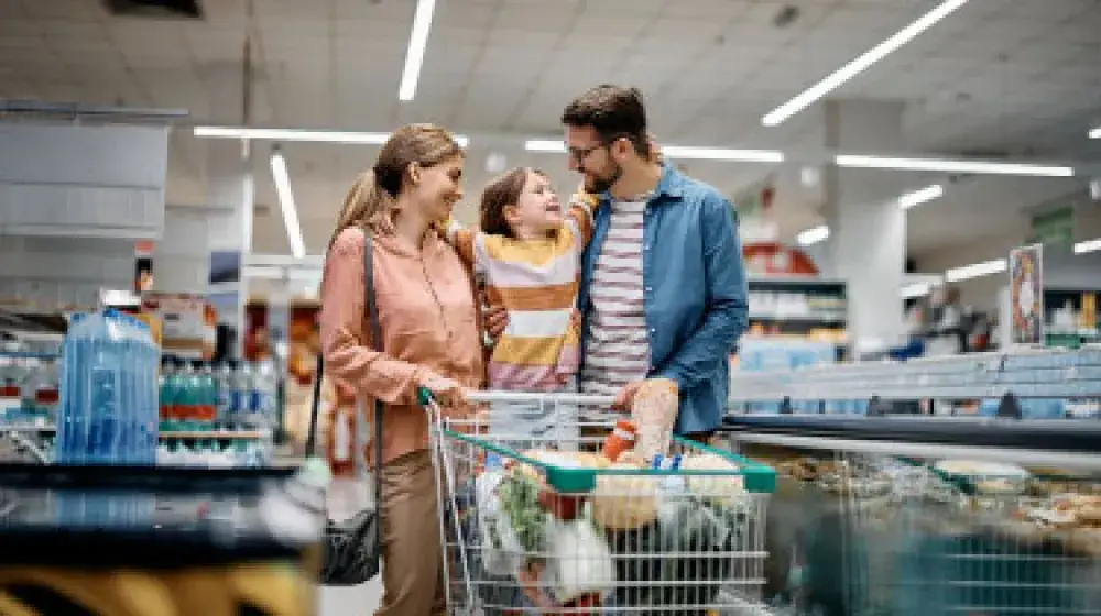 Pareja haciendo compras en supermercado junto con su hjia