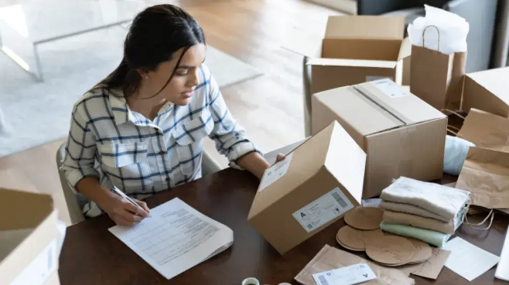 Persona empacando pedidos de su emprendimiento, el cual pudo abrir gracias a un Prestamo Facil de BAC Guatemala