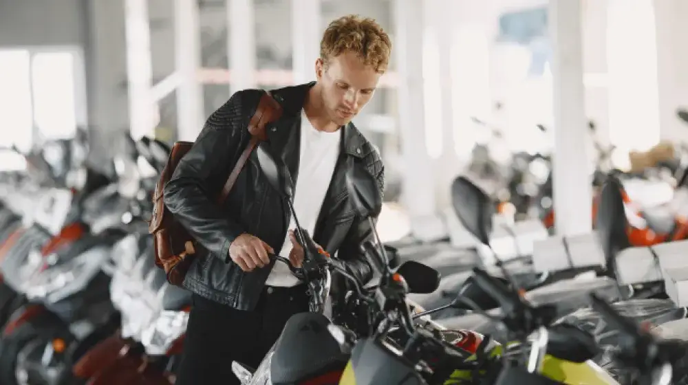 Persona revisando la motocicleta que va a comprar con el prestamo planilla de BAC Guatemala