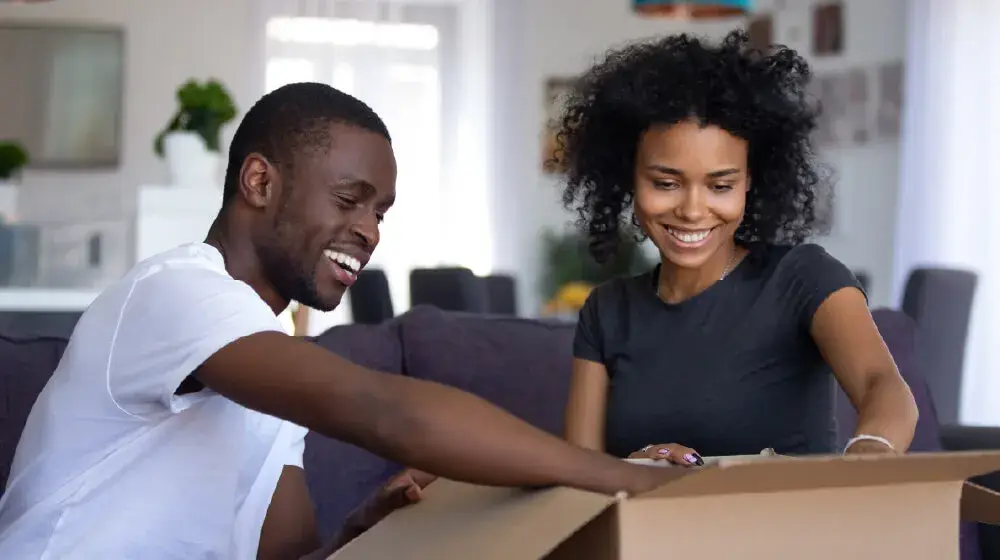 Personas abriendo un paquete recibido a través de plataformas de delivery, comprado con su tarjeta amex platinum card de bac guatemala