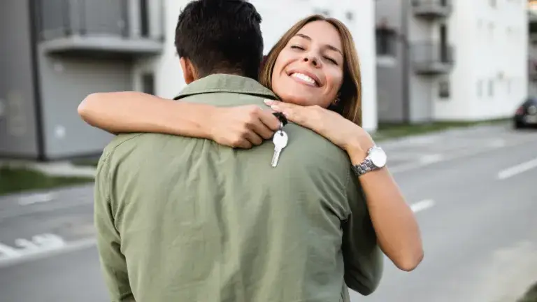 Pareja abrazados y sosteniendo llave de hogar