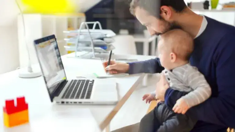 Producto Plan de Pensión Voluntaria - Hombre redactando carta con bebe en los brazos