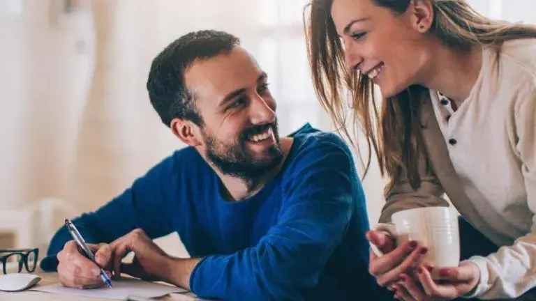 Ahorro Programado, hombre y mujer sonriendo mirándose atentamente