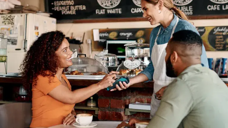 Chica pagando un café con su tarjeta