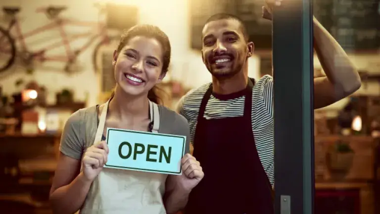 Dos personas felices abriendo su negocio 