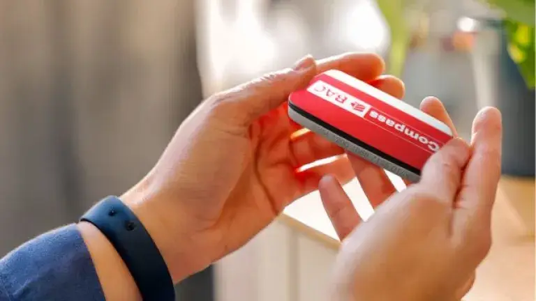 Manos sosteniendo un dispositivo Compass