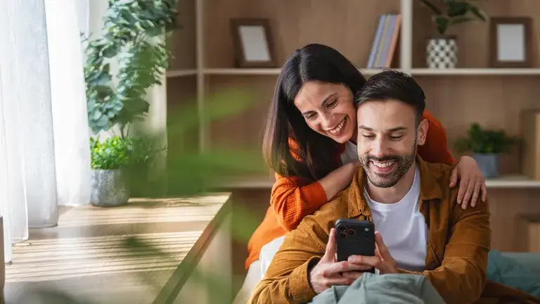 Pareja feliz viendo su celular