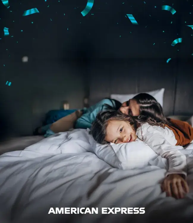 Madre e hija recostadas en cama en habitación de hotel