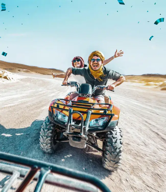 Jovenes felices manejando moto en las dunas