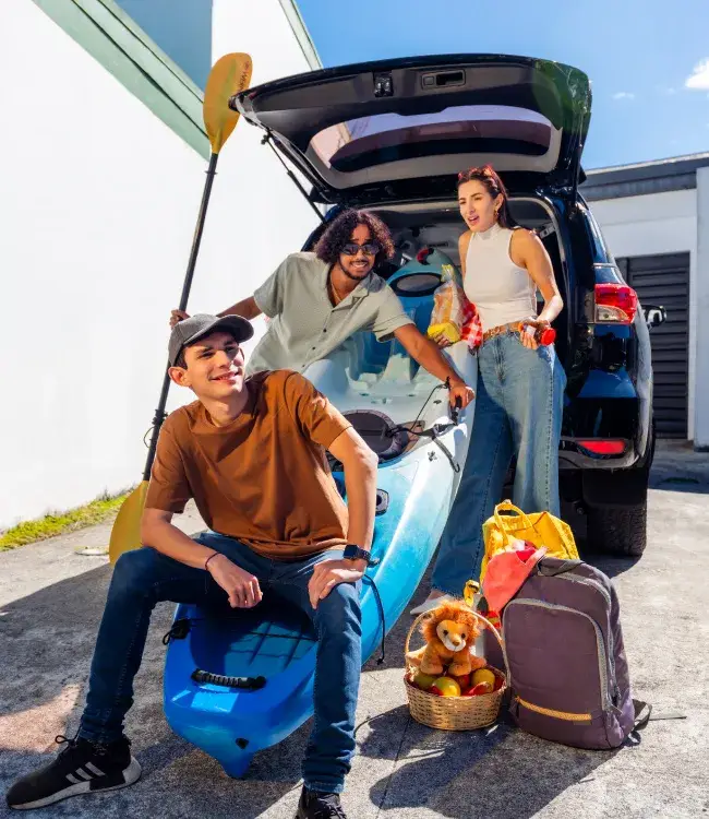 Grupo de amigos empacando para vacacionar en su nuevo vehiculo adquirido con BAC Costa Rica y Expomovil