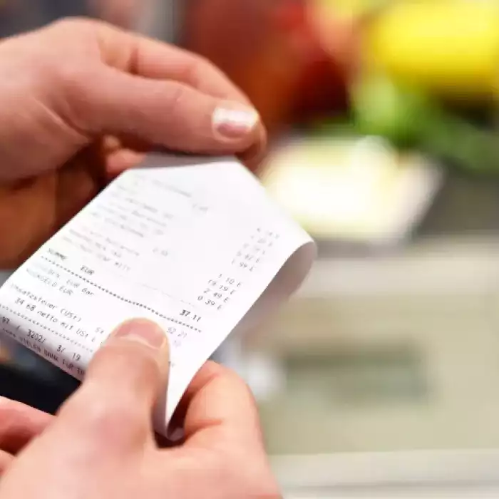 Persona revisando su factura al hacer sus compras