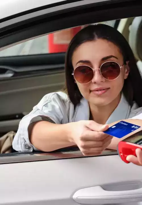 personas pagando con tarjeta Cashback para gasolineras